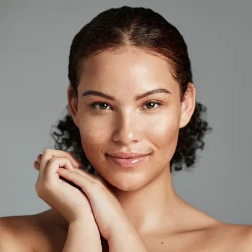Health, natural and black woman skincare portrait for beauty cosmetic and glow treatment campaign. Healthy body care of model happy with beautiful freckles on face in gray studio background.
