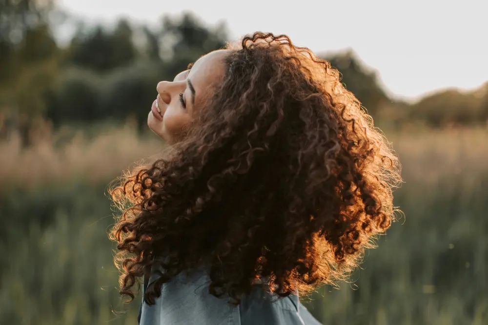 woman with curly hair in sun