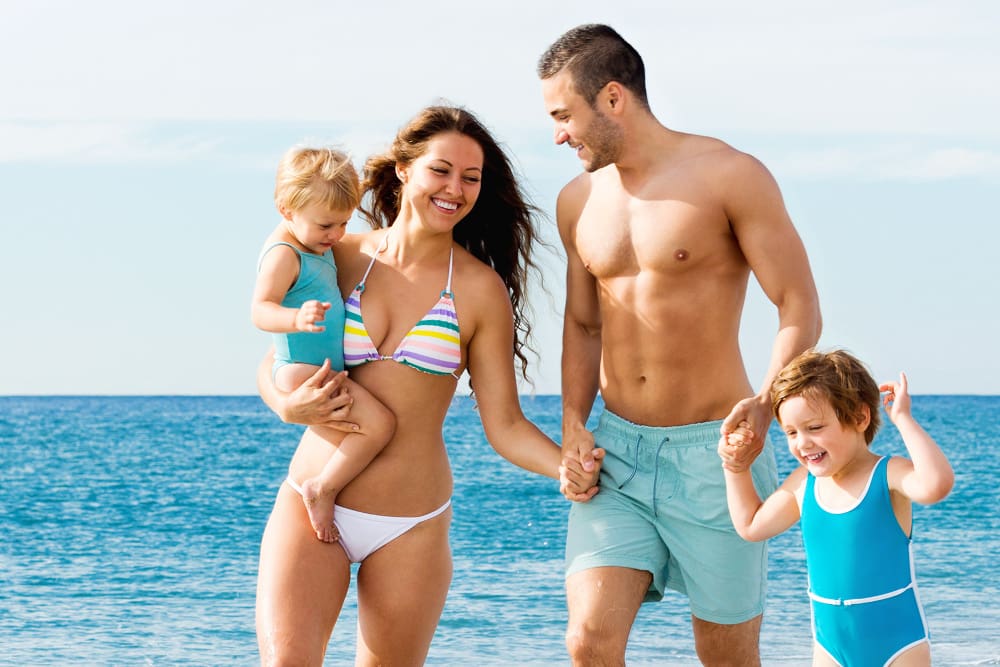 Summer vacation of smiling family with two kids on beach